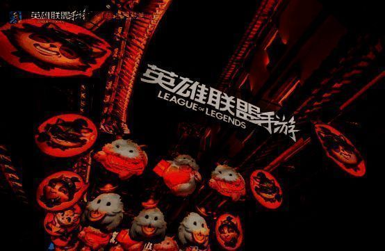 现实中的豫园灯会展区，巨型提莫花灯矗立中央，周围游客拍照打卡，灯笼上印有游戏LOGO与角色剪影