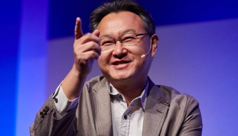 日本独立游戏展台上玩家试玩游戏的画面，展位布置温馨且富有个性，墙上贴满手绘风格的宣传海报