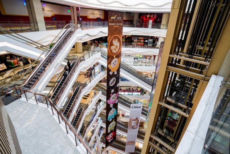 快闪店内游客排队参与互动游戏，背景墙上布满蛋仔与金饰结合的艺术装置