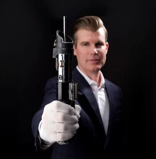 《夺宝奇兵》电影道具展示：棕色皮质探险腰带与缠绕整齐的长鞭并列陈列于黑色绒布展台