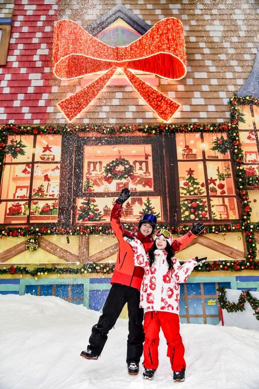 广州热雪奇迹内部全景，白雪皑皑的滑雪场被绚丽灯光与圣诞装饰包围