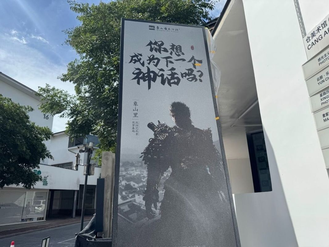 《黑神话：悟空》主题周边实物展示，包含徽章、明信片与定制笔记本