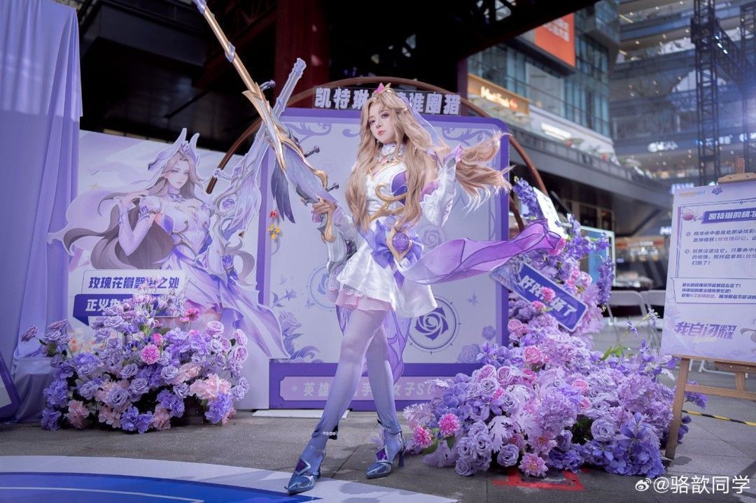 骆歆身穿水晶玫瑰凯特琳COS服装，手持狙击枪摆出经典姿势，背景为欧式花园布景