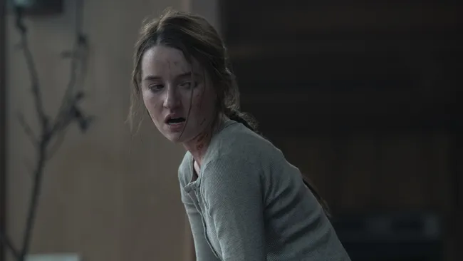 尼尔·德鲁克曼在采访中神情专注，背景为《最后的生还者》剧集宣传画面