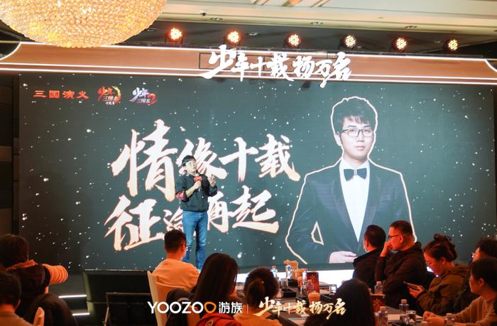 陈光龙在台上激情演讲，背景显示‘国产卡牌十年发展’数据图表