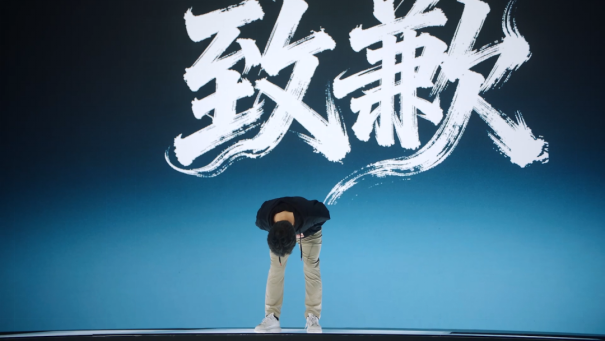 制作人星一在台上90度鞠躬，神情凝重，背景屏幕显示‘此生无悔入大荒’字样