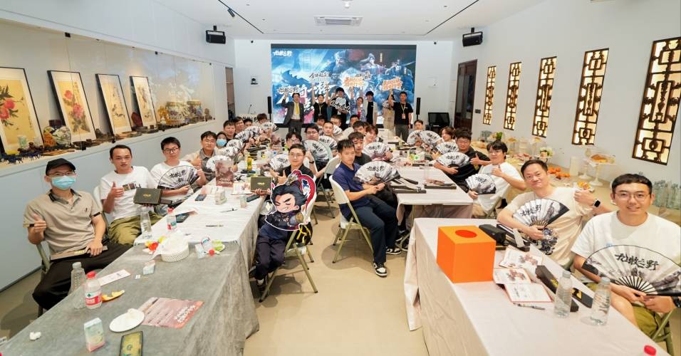 《九牧之野》深圳试玩会现场图，玩家们正在专注操作设备进行实机测试，背景展示游戏战斗画面