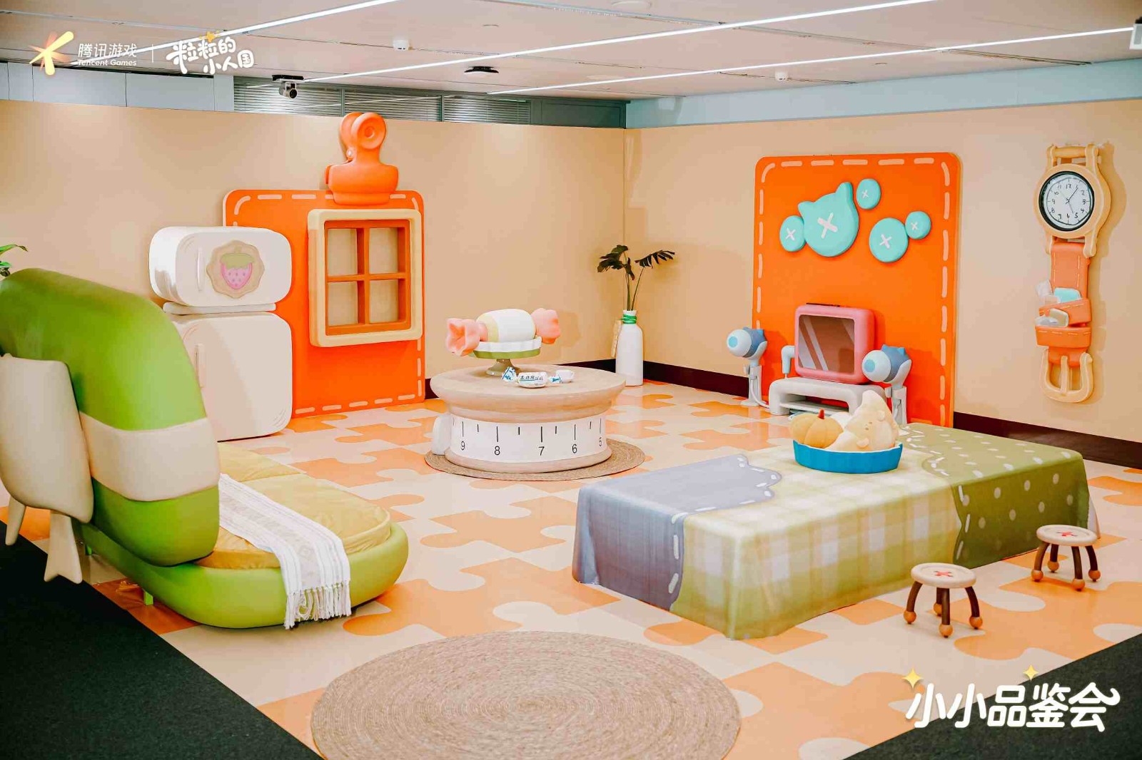 线下品鉴会现场实景图，还原游戏内客厅布局，嘉宾置身微型家具中拍照互动，氛围温馨有趣