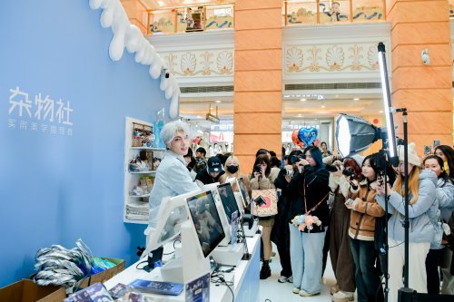九木杂物社快闪店内景，顾客围聚在初音未来展柜前合影，整体空间充满未来感与艺术氛围