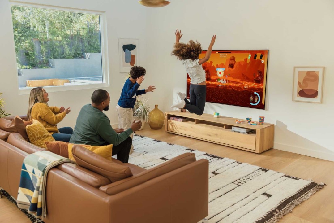 Nex在CES展会上展示Playground主机配套的体育游戏配件，包括柔软材质的网球拍、棒球棍、篮球和冰球杆，现场布置充满运动氛围