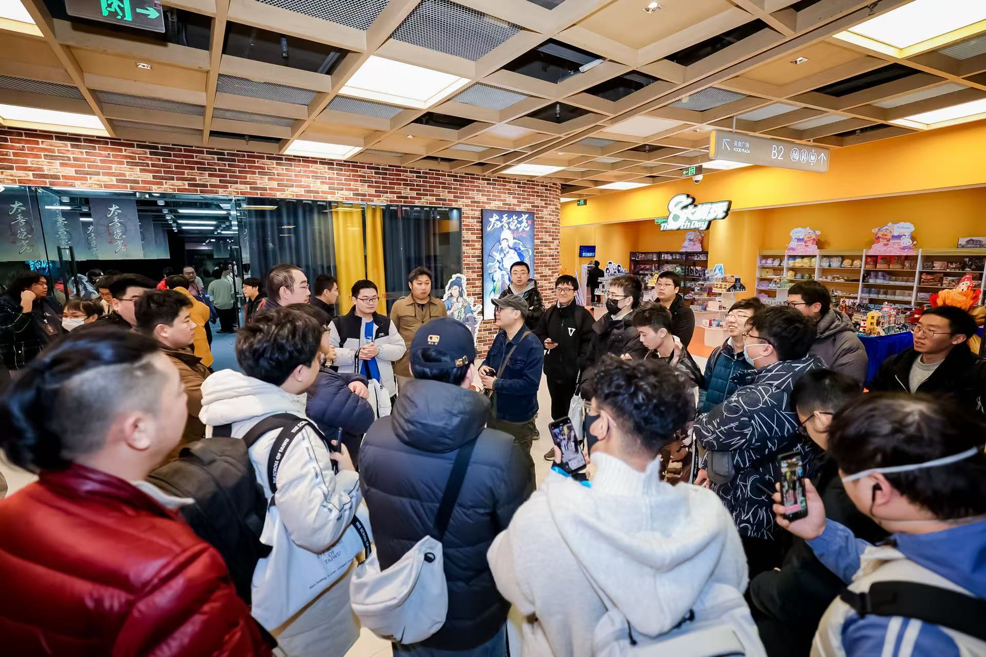 《太吾绘卷：天幕心帷》鸿蒙版试玩会现场全景图，舞台中央大屏展示游戏水墨风UI界面，台下观众手持华为设备专注体验，背景LED呈现‘鸿蒙×太吾’联合LOGO