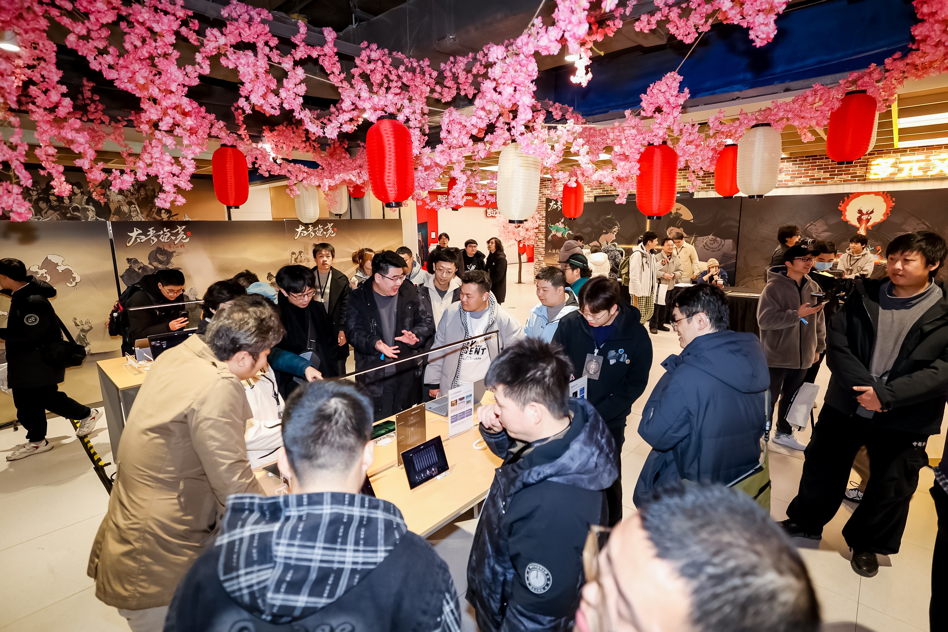 试玩会闭幕合影：《太吾绘卷》开发团队与华为鸿蒙游戏技术负责人并肩而立，背景大屏定格游戏标志性‘心帷’水墨转场动画，众人手持印有‘鸿蒙×太吾’的定制折扇