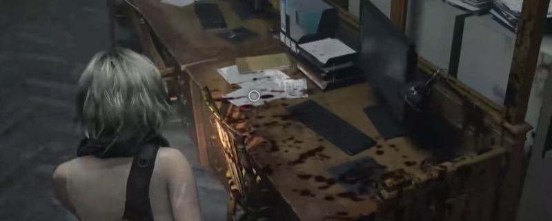 《生化危机9：安魂曲》游戏内实机画面：昏暗光线下，主角手持战术手电照射中央大堂左侧办公室桌面，桌上散落着泛黄纸张与带血指纹的密码档案