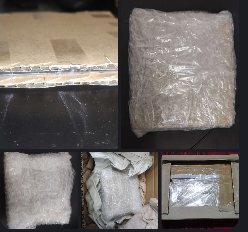 寄件前拍摄的完整包装图：牛皮纸箱内填充大量碎纸屑，中央嵌入白色硬质纸托，软盘安放其中，四周空隙填满银色气泡膜