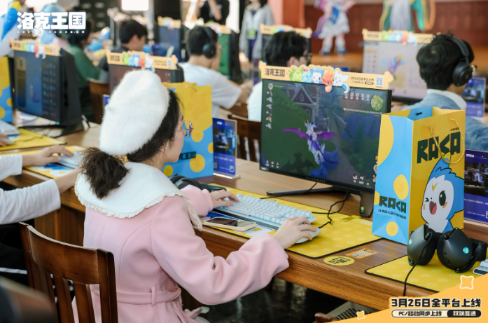 广州塔内场试玩区实景：玩家围站在多台测试机前专注操作，背景为高清3D渲染的魔法学院主楼与飘浮精灵特效