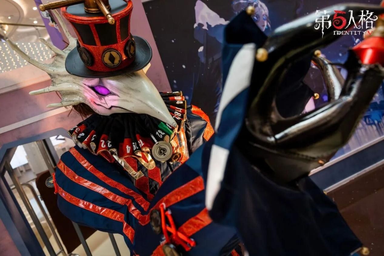 「噩梦」COSER于暗光舞台中央展开披风，背后LED屏同步播放游戏内追击动画，观众举手机闪光灯汇成星海