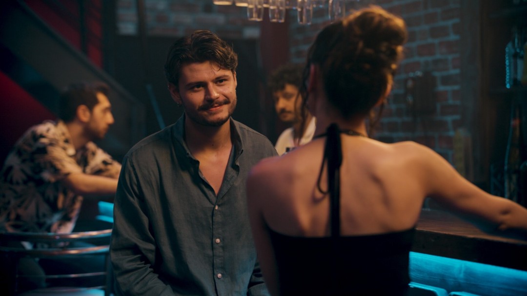 游戏实机画面：库泰与艾希尔在雨夜街头并肩行走，路灯在湿漉路面上拉出细长倒影，两人距离微妙，气氛紧绷